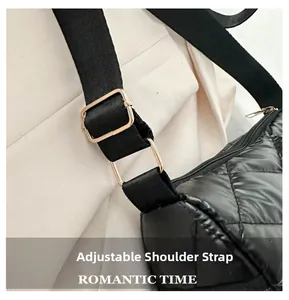Détail de la bandoulière réglable avec boucle dorée sur un sac à main matelassé noir