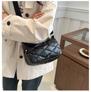 Détail d'un sac bandoulière matelassé noir avec fermeture éclair dorée