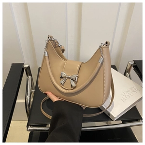 Dettaglio borsa a mezzaluna kaki con fiocco in argento e manico a catena chic