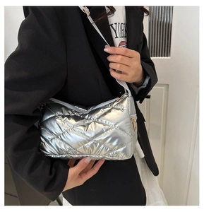 Gros plan du sac bandoulière argenté métallisé avec motif matelassé et texture bouffante