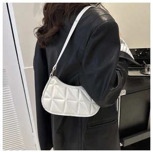 Dettaglio della borsa hobo bianca trapuntata con trama geometrica e giacca nera