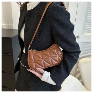 Dettaglio della borsa sottobraccio vintage marrone con motivo trapuntato su modella
