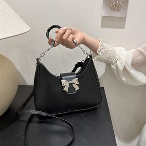 Borsa a mano nera in pelle sintetica con fiocco in metallo argento e tracolla sottile