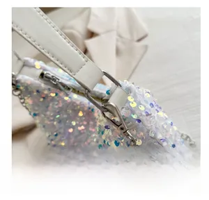 Detail of silver metal hook and chain on a white sequin bag with iridescent shimmer