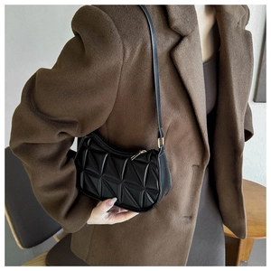 Dettaglio di una borsa sottobraccio nera trapuntata geometrica in similpelle lucida