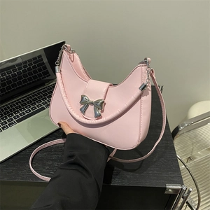 Borsa hobo rosa a mezzaluna con fiocco argento e tracolla in un contesto da ufficio