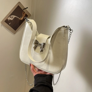 Chic cream bow shoulder bag with silver metal hardware and detachable chain strap