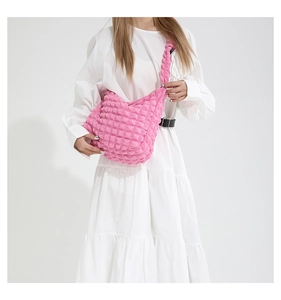 Detailed texture of pink bubble ruched fabric on a large crossbody shoulder bag