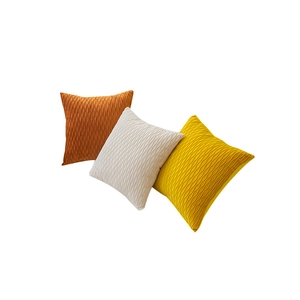 Three square velvet cushion covers in orange, beige and yellow with 3D wave textures