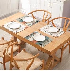 Detail of Thanksgiving placemats with pumpkins and harvest text on wooden dining table