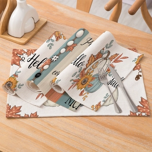 Autumn themed placemat with pumpkin and sunflower pattern on a wooden dining table