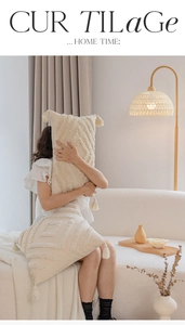 Detail of cream tufted throw pillow with bohemian tassels and geometric wave textures