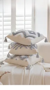 Detail of tufted boho pillow covers with grey tassels and geometric patterns