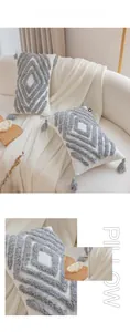 Detail of cream-colored tufted pillows with grey geometric patterns and elegant tassels