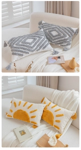 Detail of bohemian tufted pillow covers with tassels and geometric patterns on a soft sofa