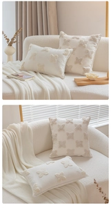 Close-up of cream tufted throw pillows with 3D floral textures in a minimalist bedroom