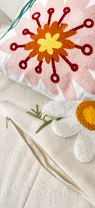 Detail of floral tufted embroidery on beige canvas pillow cover with invisible zipper