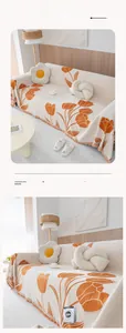 Detail of chenille sofa cover with orange tulip patterns and beige tassel fringe edge