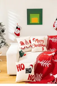 Detalle de funda de cojín navideña con bordado rojo y texto de Feliz Navidad festivo