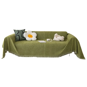 Green chenille sofa cover with fringed edges and thick knitted texture on white background