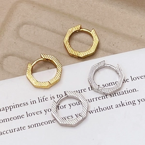 Textured hexagonal hoop earrings in gold and silver finish with diagonal stripe patterns