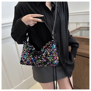 Detail of colorful sequined handbag with silver chain strap and black leather handle
