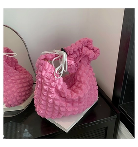 Detailed macro view of the pink pleated cloud bag with textured popcorn fabric and drawstring