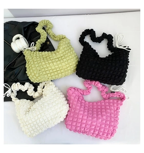 Detail of four textured popcorn cloud bags in green, black, white, and pink colors