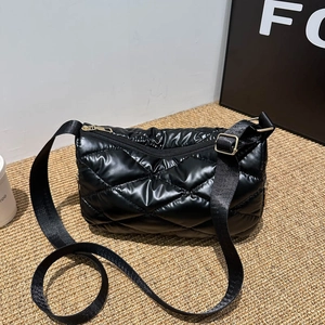 Sac bandoulière matelassé noir brillant avec finitions métalliques dorées chic