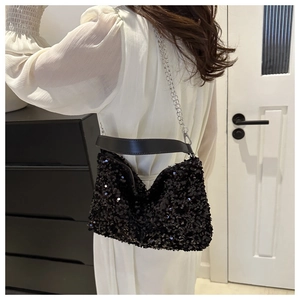 Detail of black sequin handbag with silver chain strap and wide leather handle strap