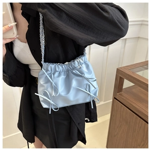 Détail du sac seau à nœuds bleu clair avec cuir PU plissé et bandoulière chaîne argent