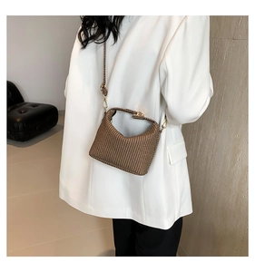 Détail de la texture tissée marron sur un sac hobo polyvalent avec garnitures dorées