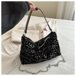 Detail of shimmering black sequins and silver chain strap on a trendy crossbody bag