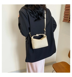 Détail du sac à main tissé beige avec bandoulière amovible et finitions dorées