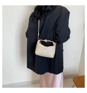 Detail der cremefarbenen geflochtenen Handtasche mit goldener Hardware am Model