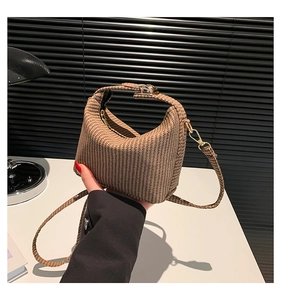 Détails de la texture du sac croissant tressé marron avec fermoir métallique et bandoulière