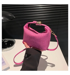 Détail du mini sac à main tissé fuchsia avec boucle dorée et finition texturée élégante