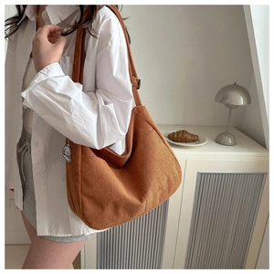 Detail view of brown corduroy tote bag showing soft texture and shoulder strap hardware