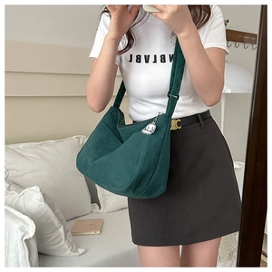 Detail view of large corduroy tote bag in dark green with cute white poodle charm