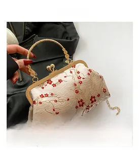 Detail of vintage Chinese silk handbag with red plum blossom embroidery and gold hardware