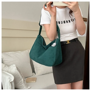 Detail view of a vintage dark green corduroy shoulder bag with an adjustable wide strap