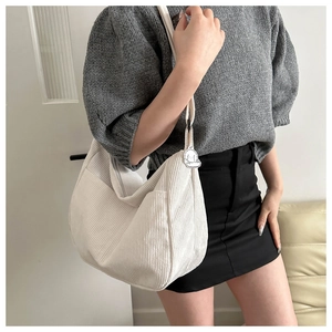 White corduroy hobo bag with cute dog charm shown on a casual model outfit