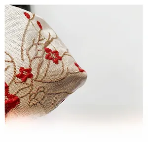 Macro shot of high-quality fabric with red plum blossom embroidery and woven texture