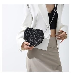 Detalle de bolso bandolera con forma de corazón, bordado de telaraña blanca y cadena
