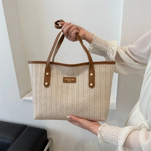Chic beige straw tote bag with brown leather handles and V-shaped weave texture