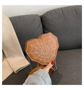Detalle del bolso bandolera de cuero con forma de corazón, costuras de telaraña y cadena