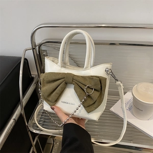 Mini white leather shoulder bag with oversized green bow and silver chain strap