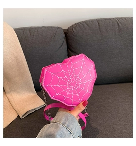 Detalle de bolso bandolera rosa con forma de corazón y costuras de telaraña blanca