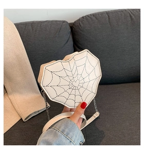 Detalle de bolso bandolera blanco en forma de corazón con costuras negras de telaraña