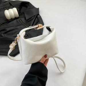Petit sac carré blanc à texture tressée avec bandoulière dorée présenté de près